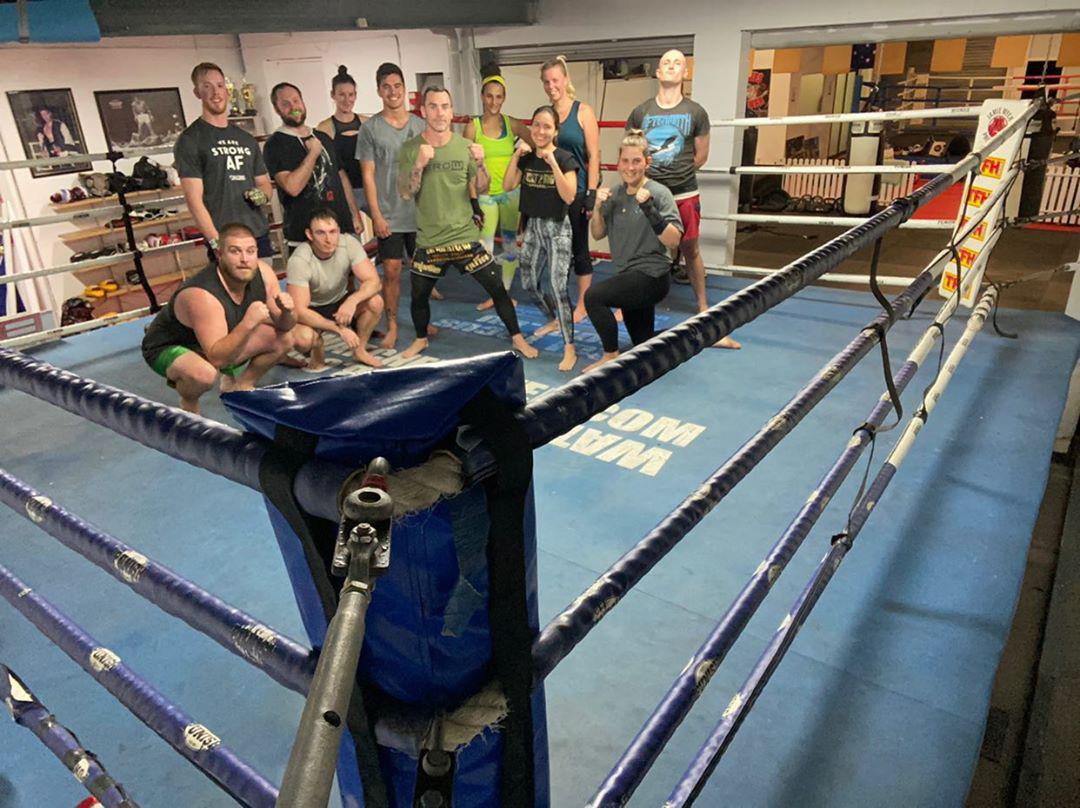 Members posing together in the ring after a session