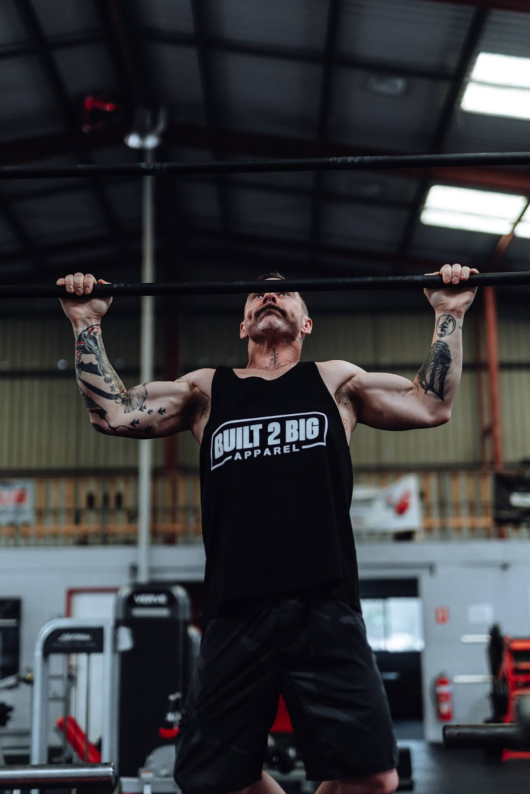 Shaun, coach and owner of Guns At Dawn, doing pull-ups in the gym